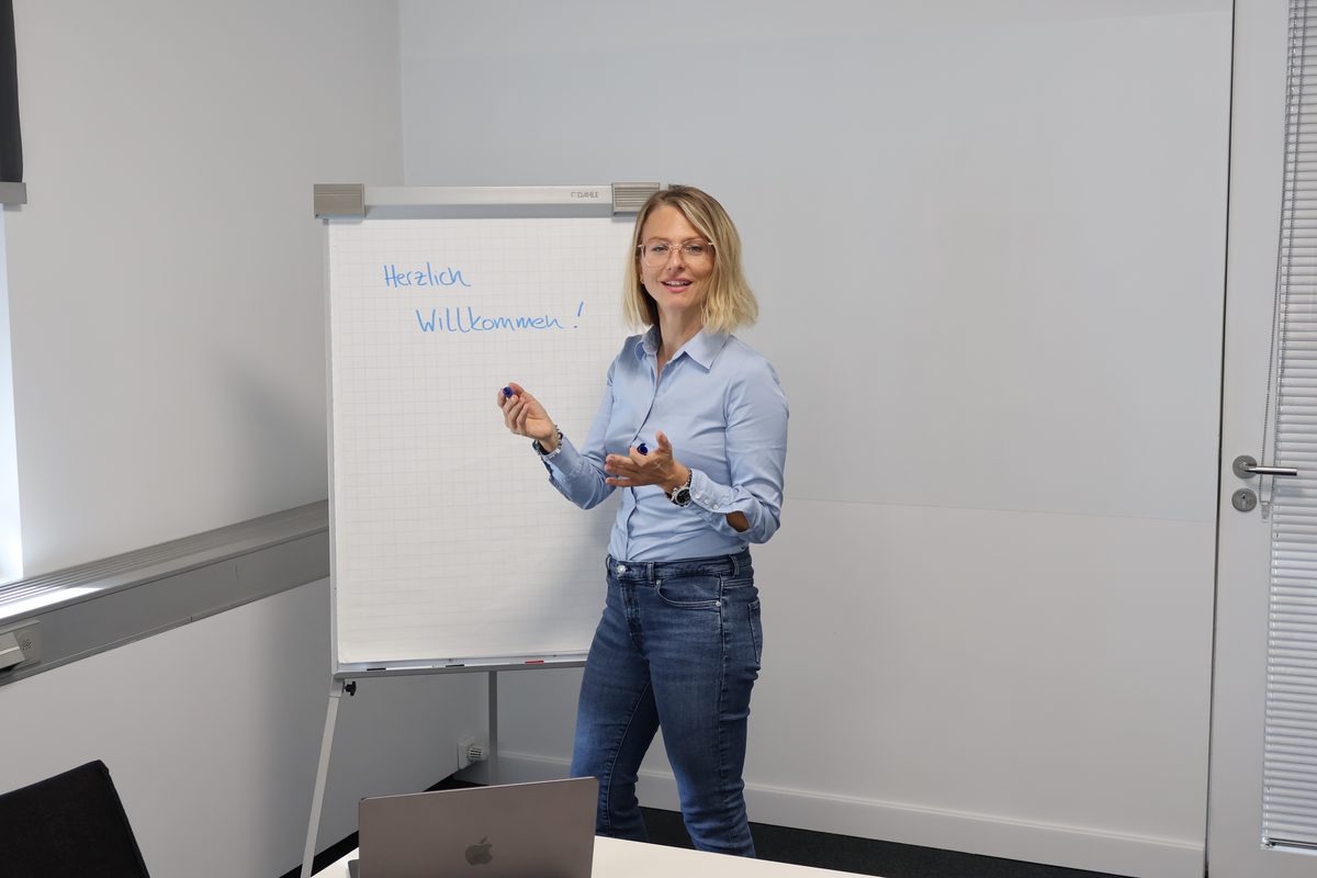 Yvonne Brinkhaus am Flipchart mit der Aufschrift Herzlich Willkommen