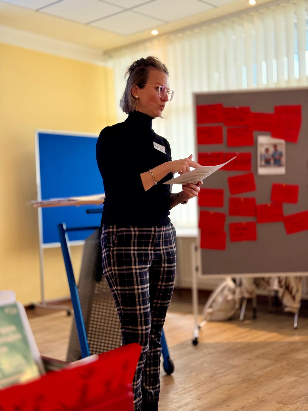 Yvonne Brinkhaus liest Karten an einer Pinnwand