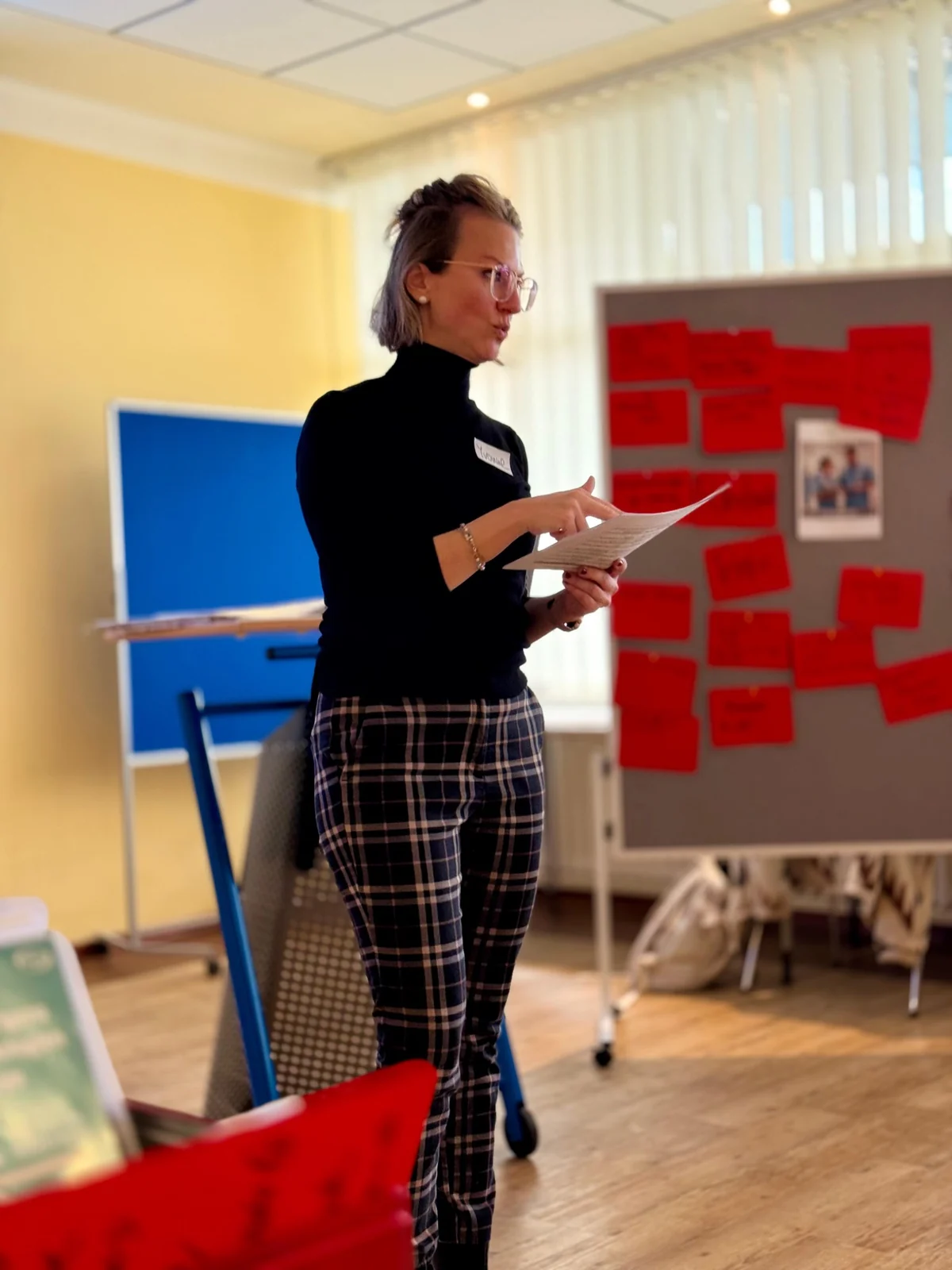 Yvonne Brinkhaus moderiert stehend einen Workshop vor einer Gruppe